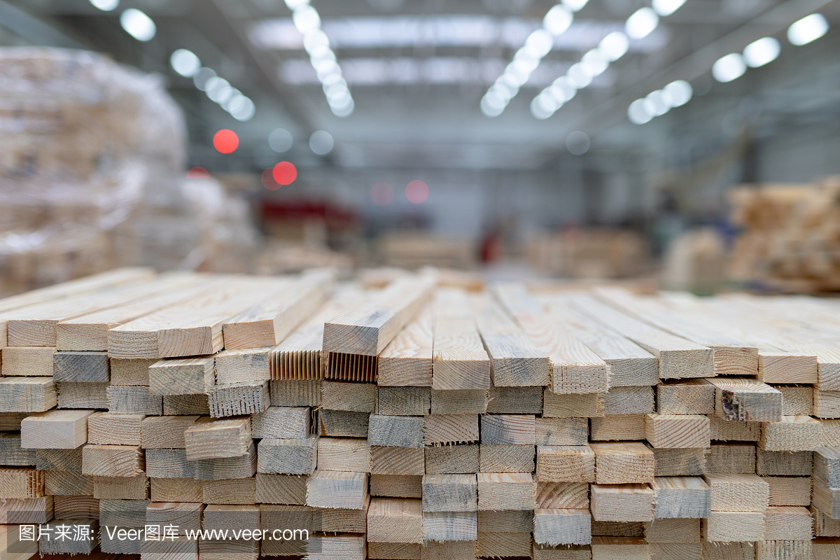 木工车间里的一堆木板。木材工业工厂准备生产的木材光背景。